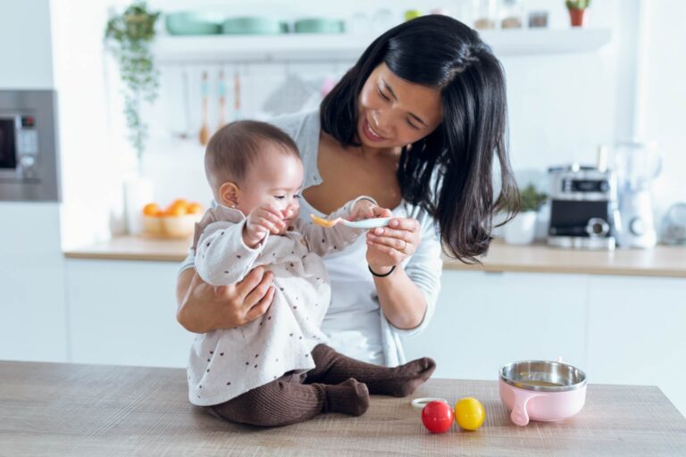 happy-young-mother-feeding-her-cute-baby-girl